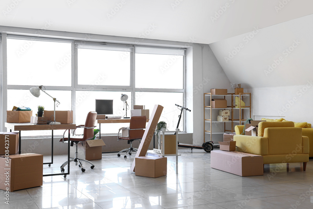 Interior of office with cardboard boxes on moving day