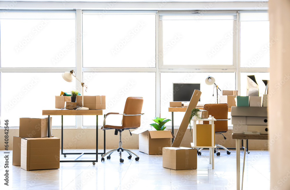 Interior of office with cardboard boxes on moving day