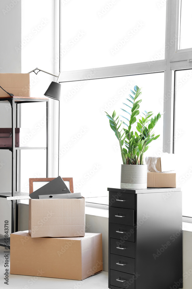 Interior of modern office with cardboard boxes on moving day