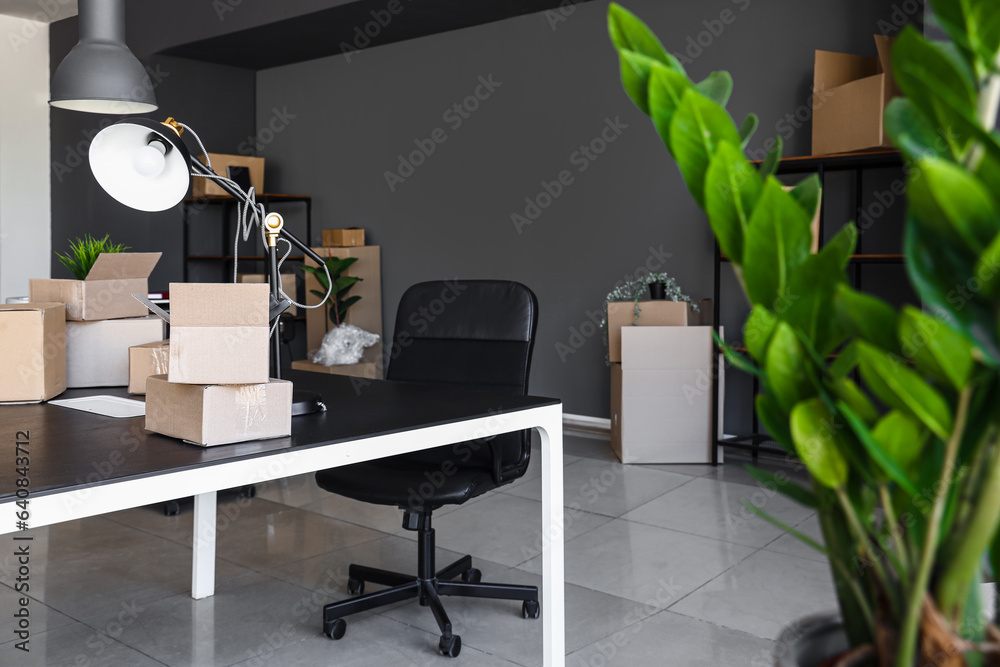 Interior of modern office with cardboard boxes on moving day