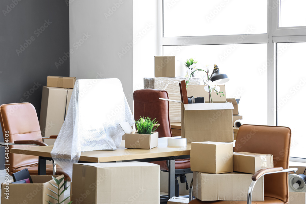 Interior of modern office with cardboard boxes on moving day