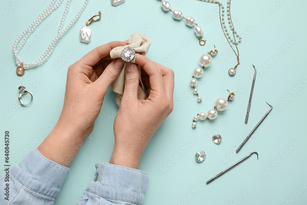 Female hands with beautiful jewelry and cleaning tools on color background, closeup