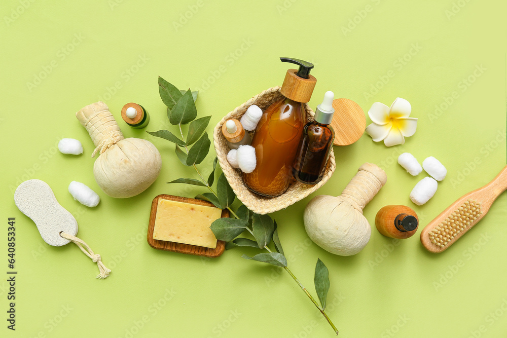 Composition with cosmetic products, spa accessories and eucalyptus branch on green background