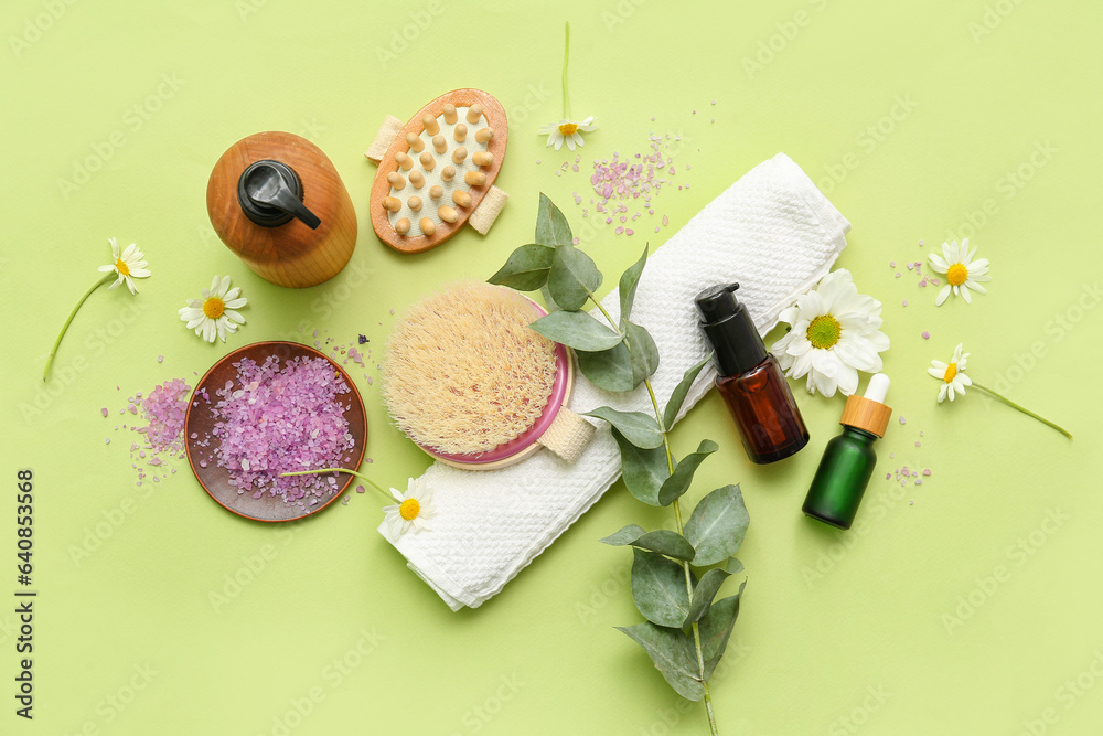 Composition with bath supplies, cosmetic products and flowers on green background