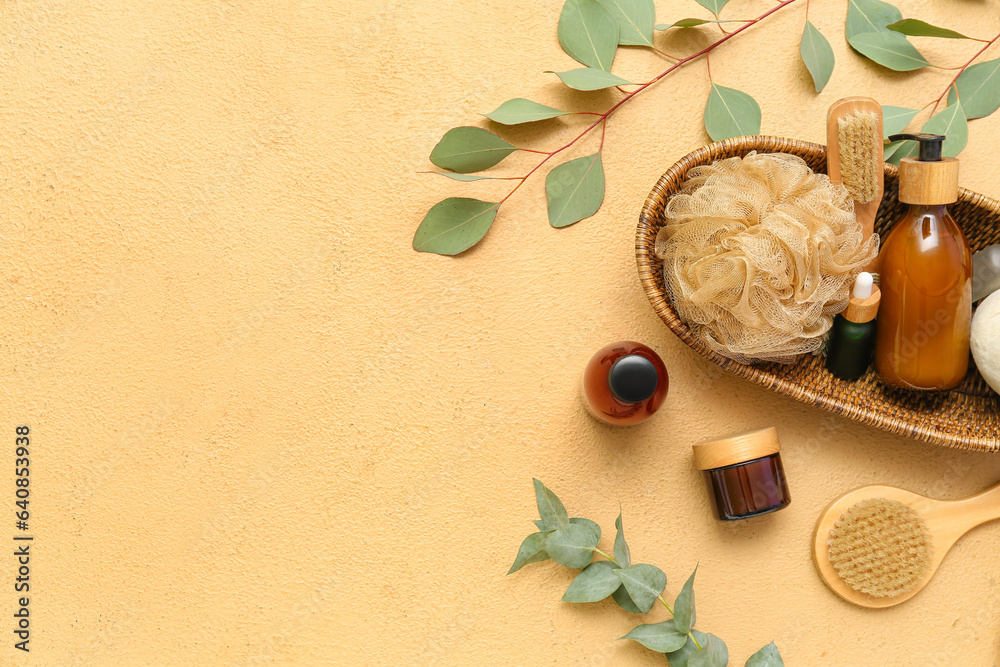 Composition with cosmetic products, bath accessories and eucalyptus branches on color background