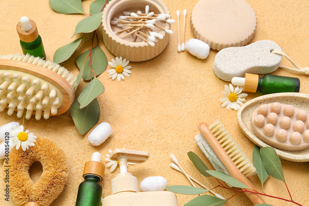 Frame made of cosmetic products, bath supplies and eucalyptus branches on color background, closeup