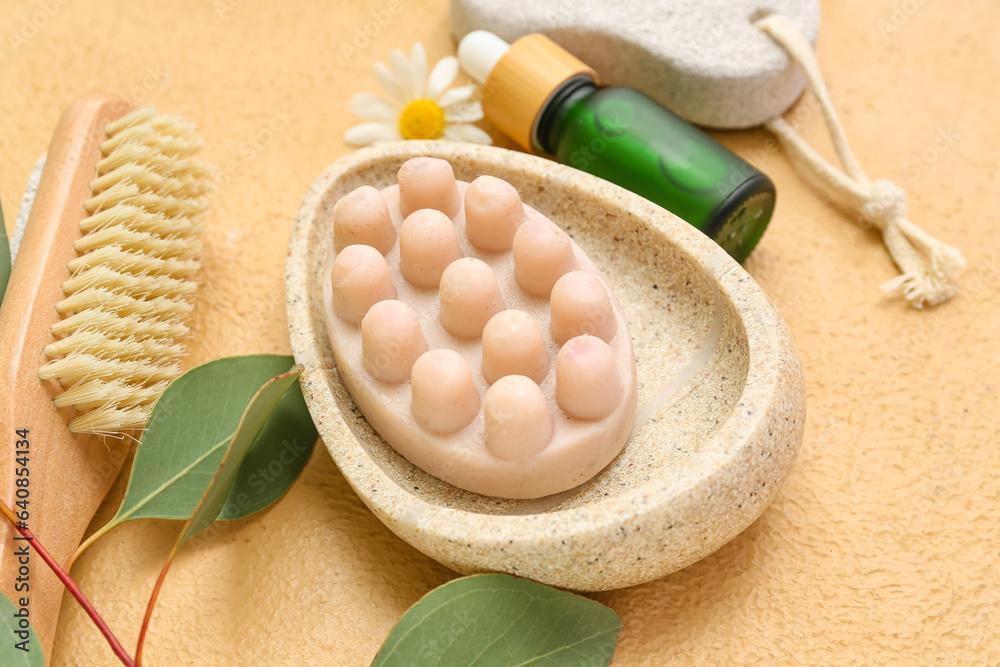 Bowl with massage soap, essential oil and bath supplies on color background, closeup