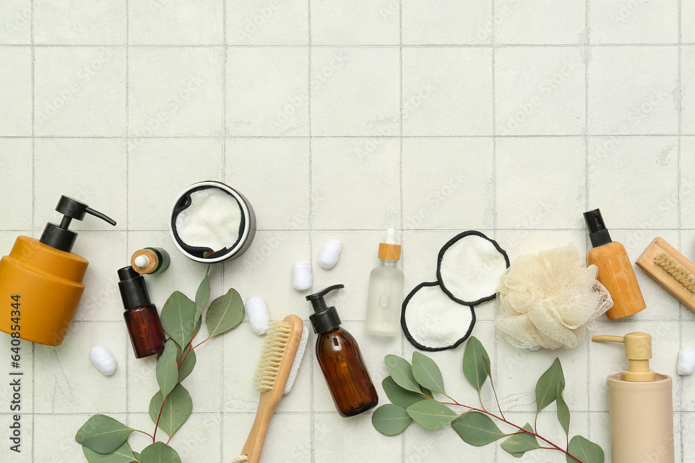 Composition with different bath supplies, cosmetic products and eucalyptus branches on light tile ba