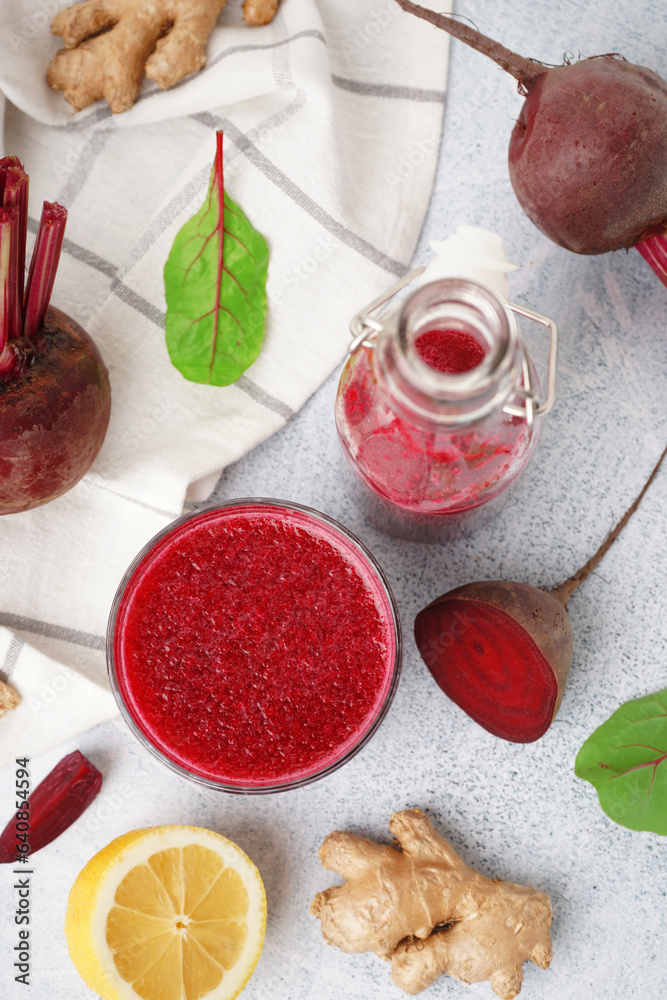 Bottle and glass of fresh beetroot juice with ingredients on light background