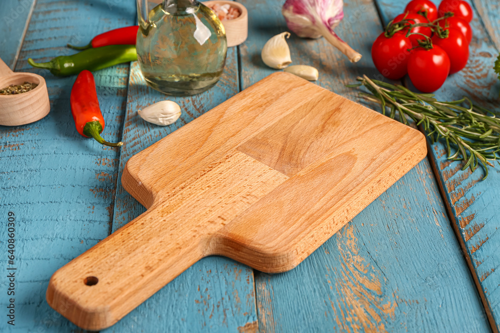 Composition with cutting board, vegetables and spices on color wooden background