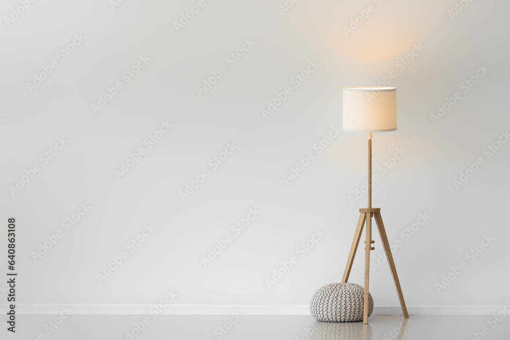 Glowing lamp with pouf in light room