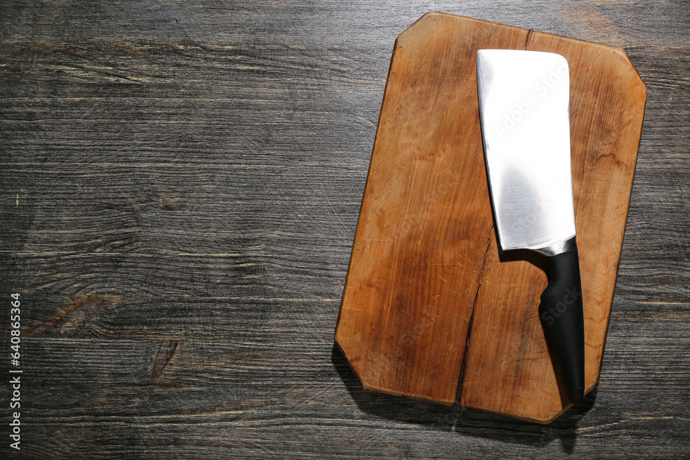 New cutting board and meat cleaver on wooden background