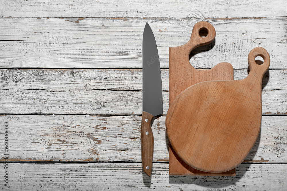 Different cutting boards on light wooden background