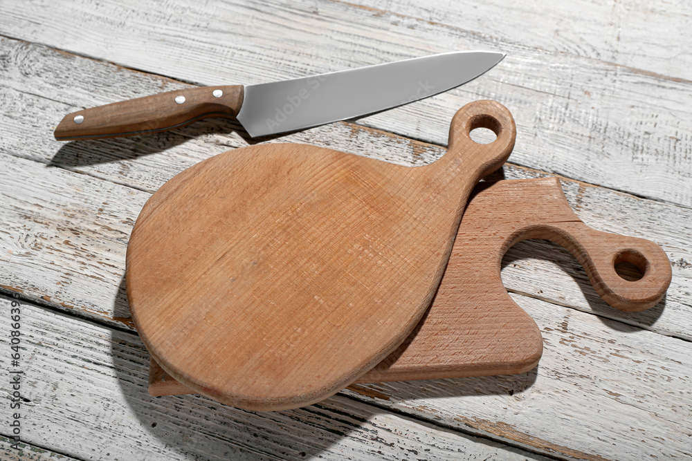 Different cutting boards on light wooden background