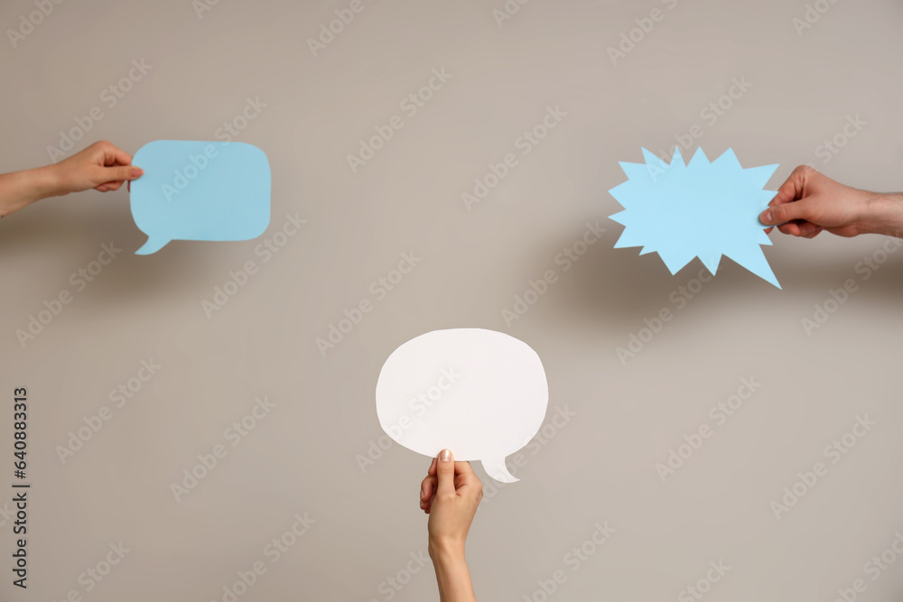 Different hands with speech bubbles on grey background