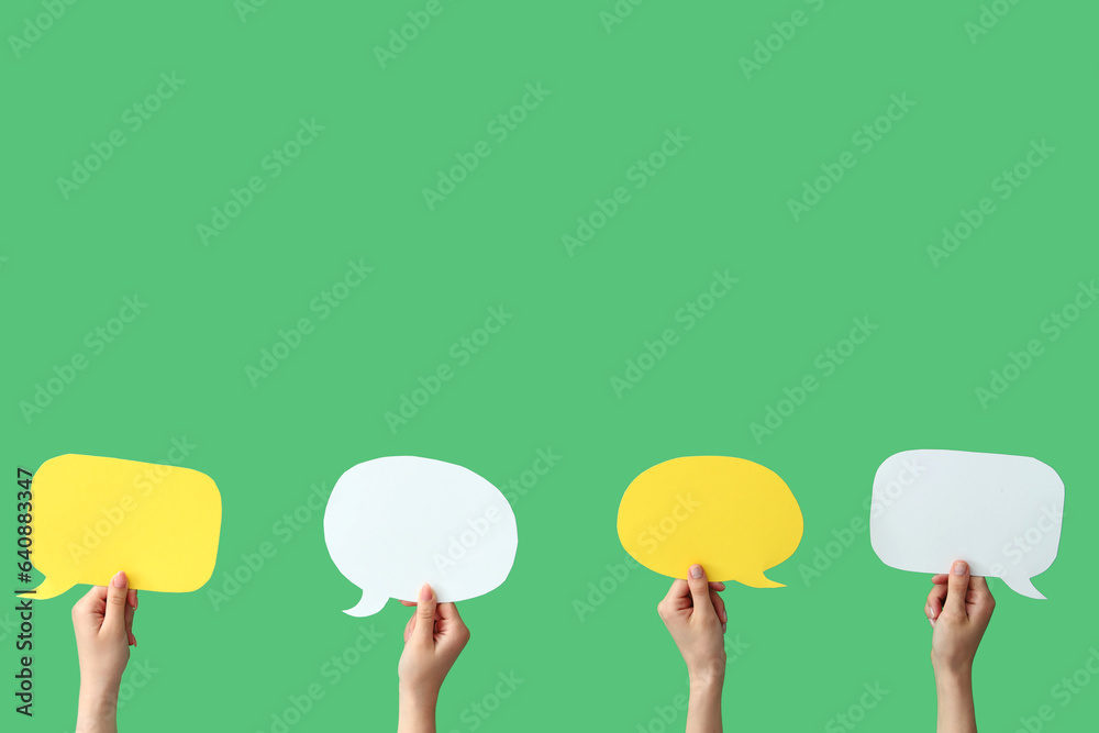 Female hands with speech bubbles on green background