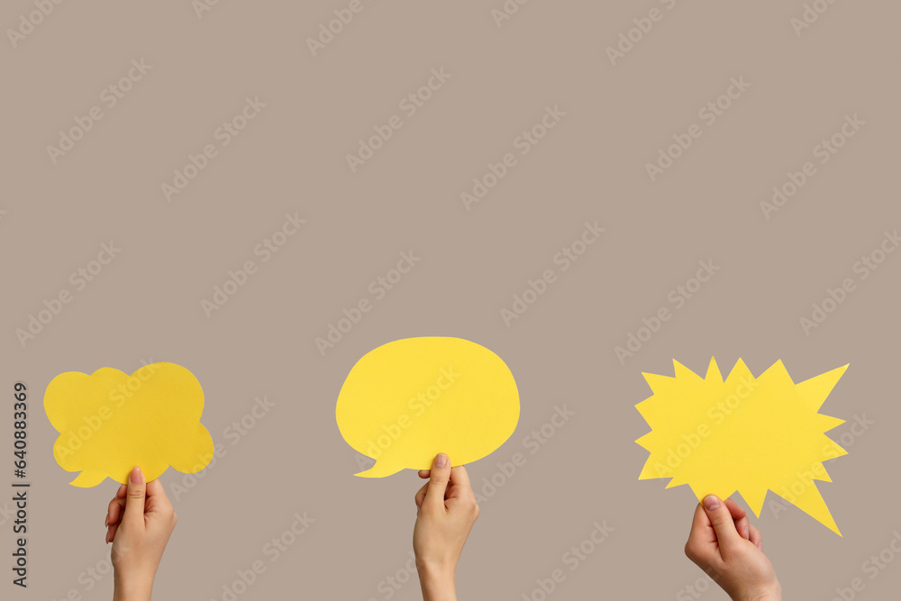 Different hands with speech bubbles on grey background