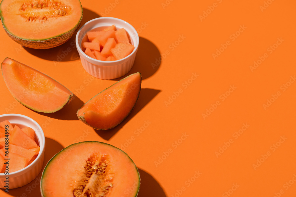 Sweet melons and bowls with pieces on orange background