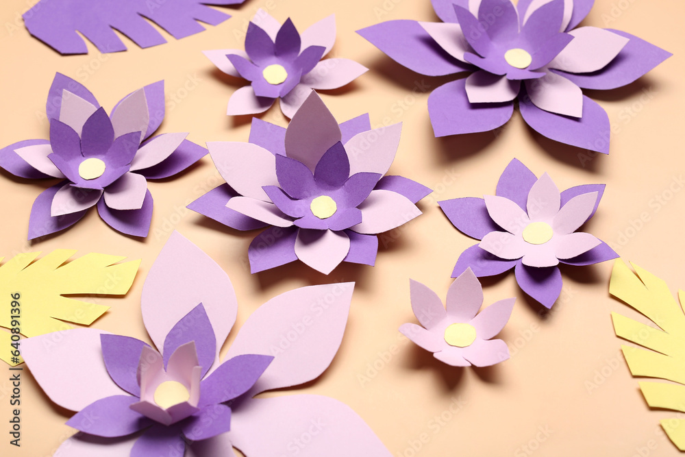 Colorful origami flowers with leaves on beige background