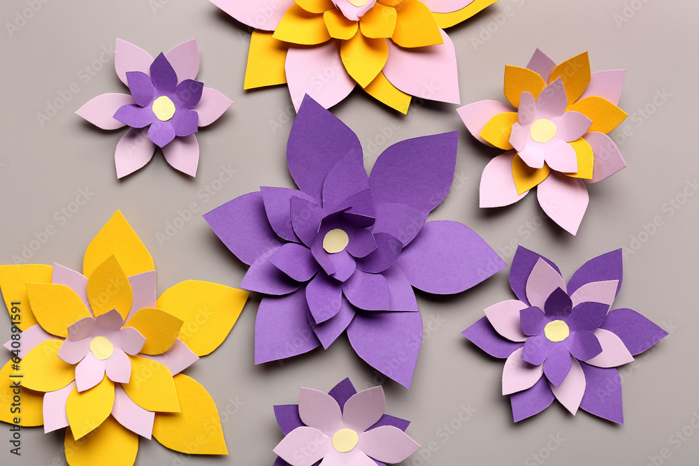 Colorful origami flowers on grey background