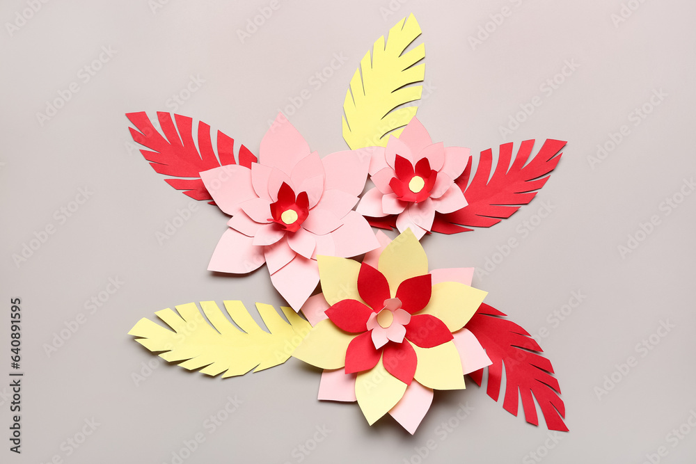 Colorful origami flowers with leaves on grey background