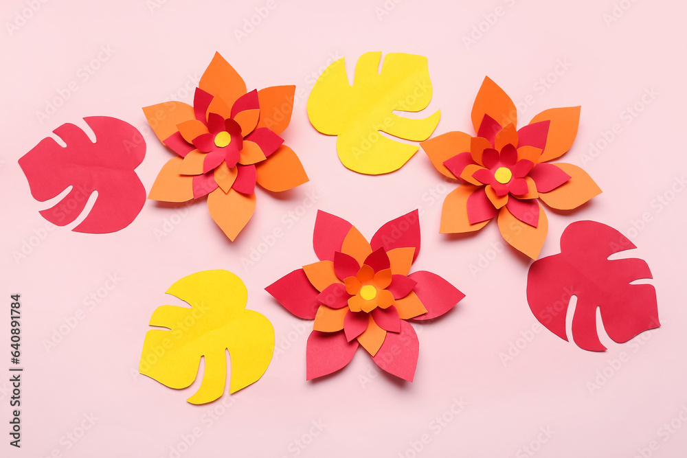 Colorful origami flowers with leaves on pink background