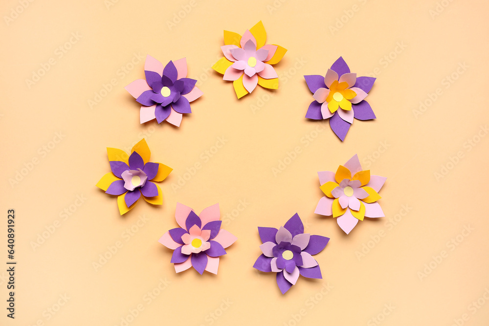 Frame made of colorful origami flowers on beige background