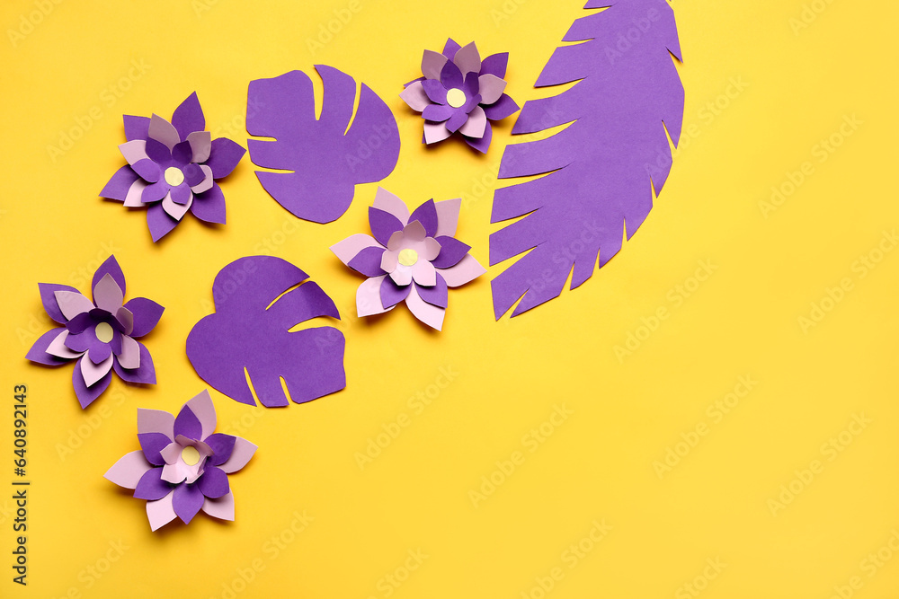 Colorful origami flowers and leaves on yellow background