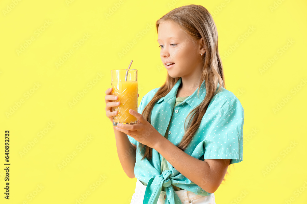 Little girl with glass of fresh citrus juice on yellow background