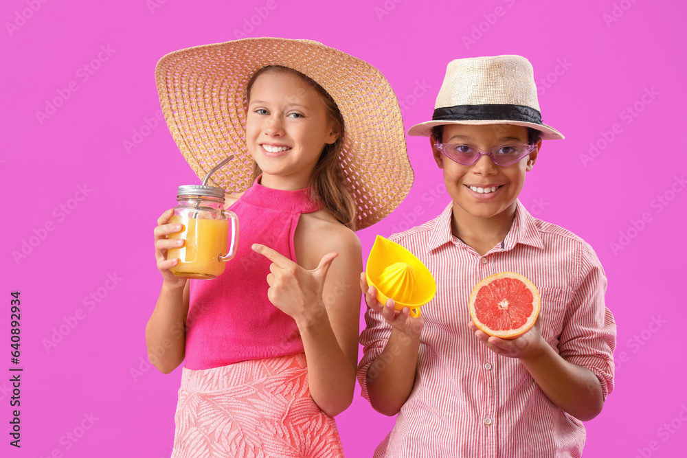 Little children with mason jar of fresh citrus juice, squeezer and grapefruit slice on purple backgr