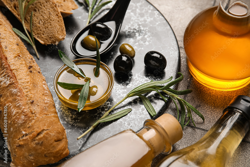 Bowl of oil, bread and olives on table