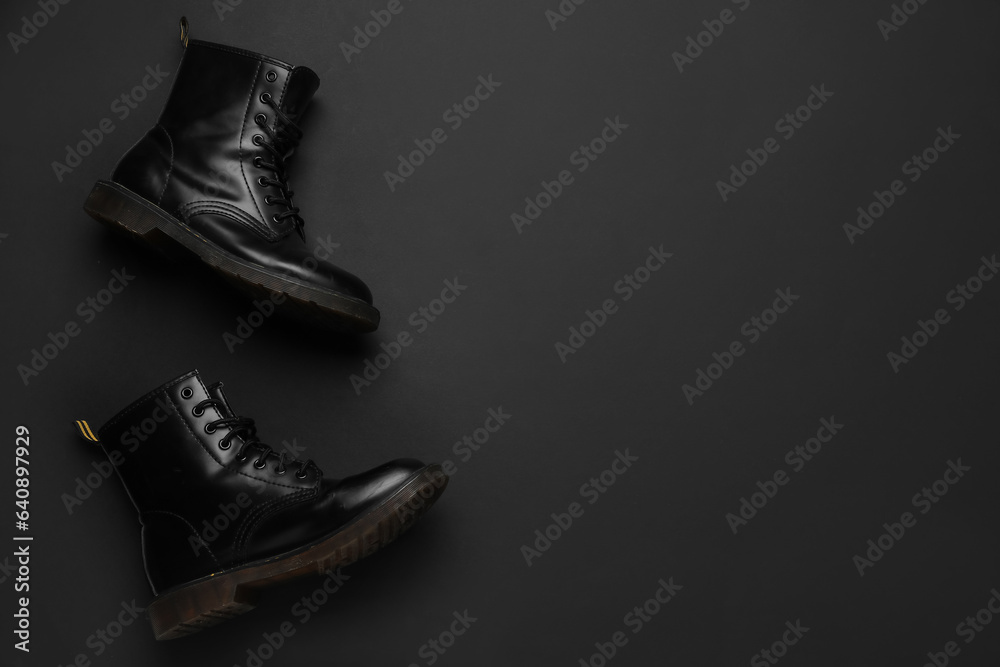 Stylish leather boots on black background