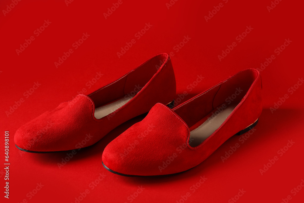 Stylish red ballet flats on color background