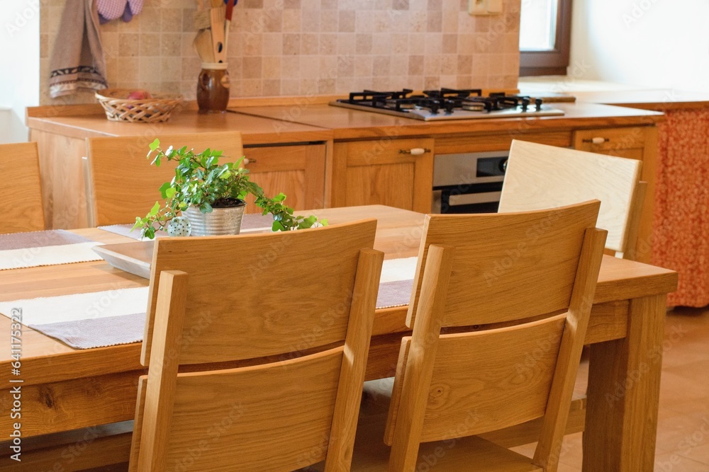 Solid wood kitchen furniture. Table and chairs, cozy home interior.