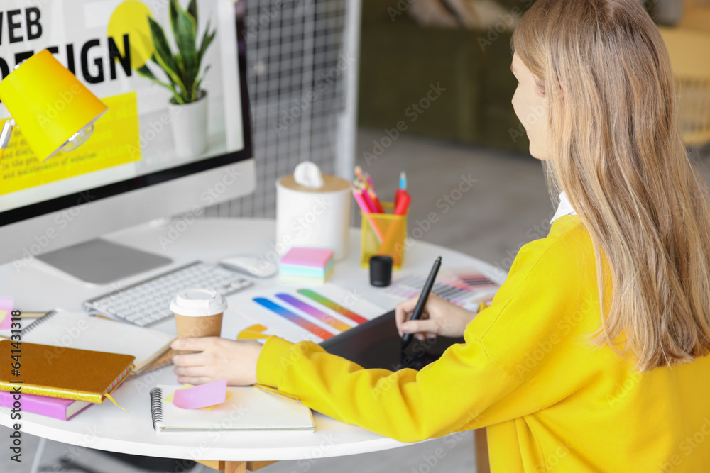 Female graphic designer working with tablet at table in office