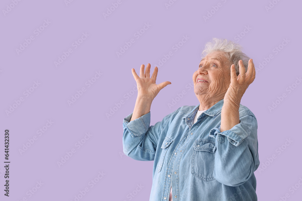 Happy senior woman on lilac background