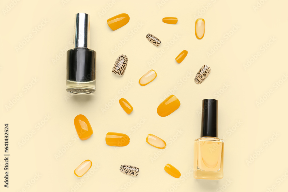 Press-on nails with polishes on yellow background