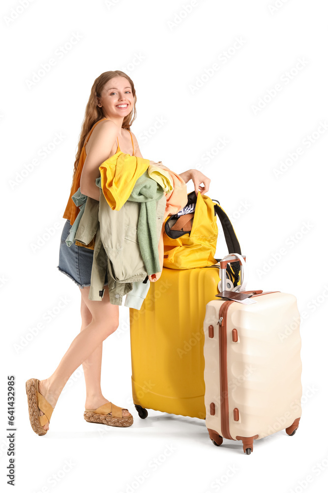 Young woman packing her clothes in backpack on white background