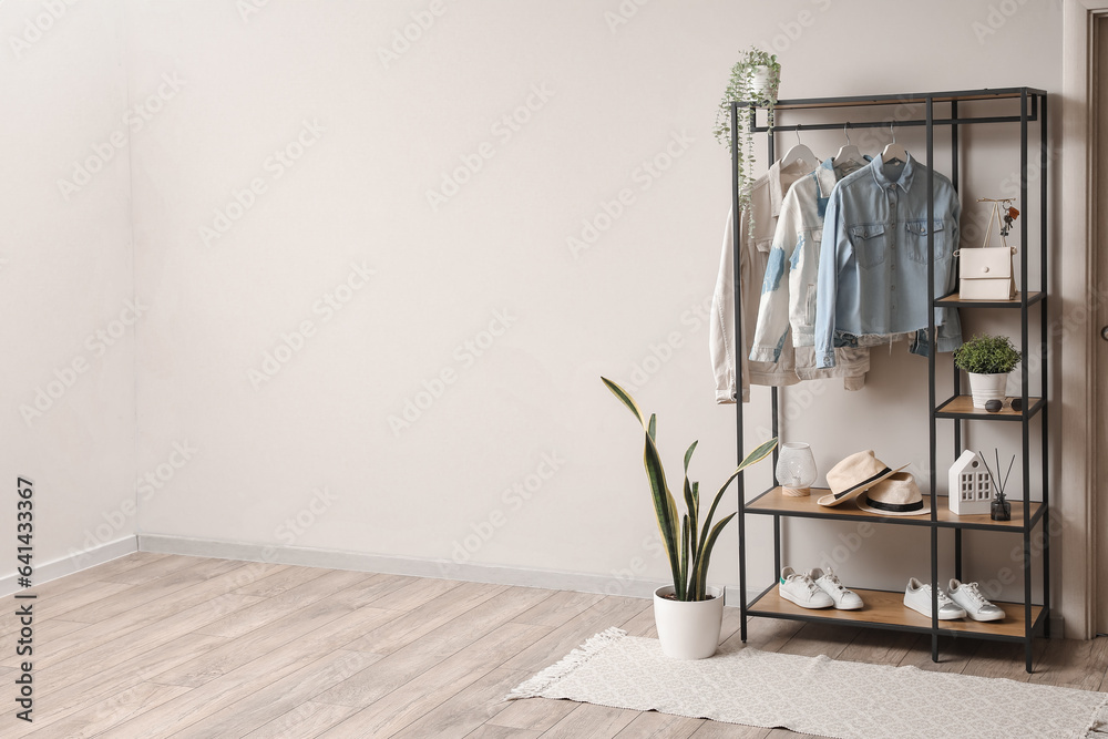 Shelving unit with clothes and accessories in modern hall