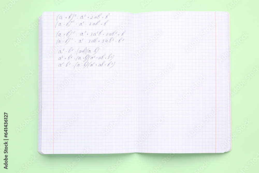 Copybook with maths formulas on green background