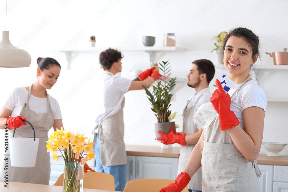 Young janitors cleaning in kitchen