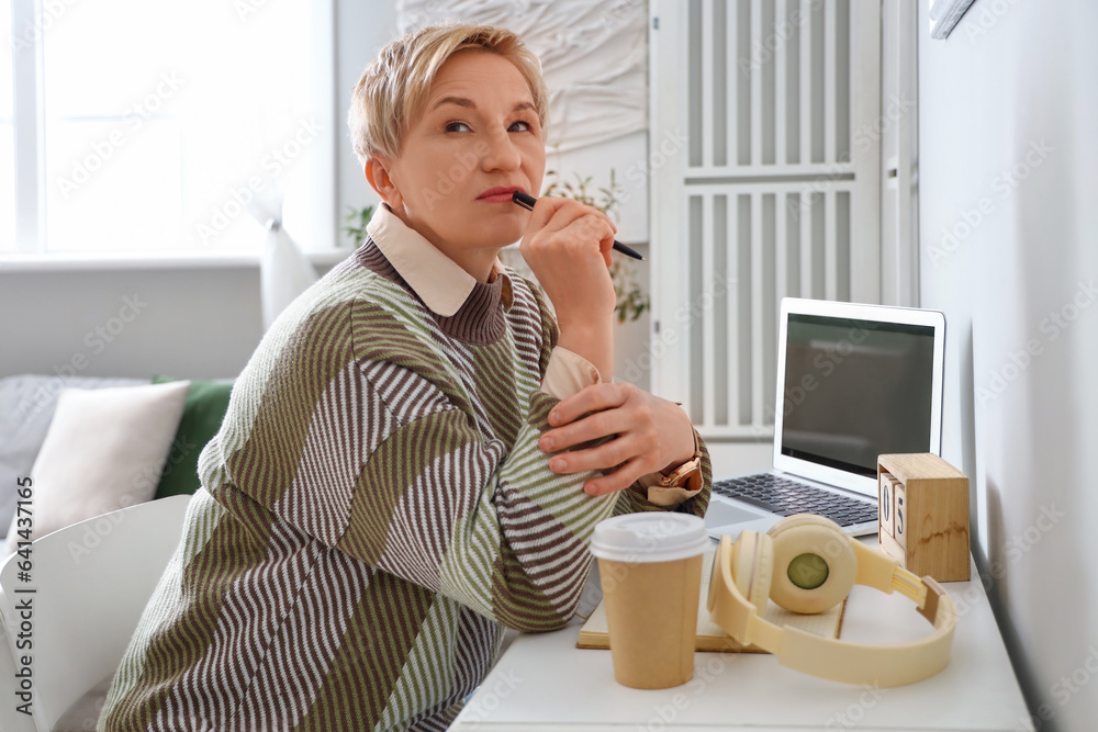 Thoughtful mature woman sitting at home