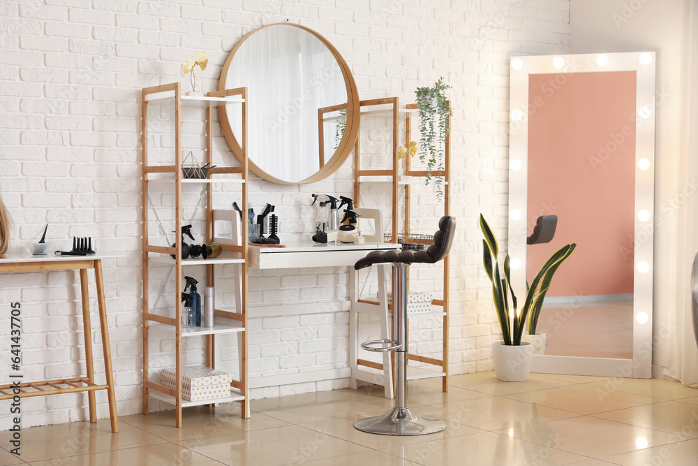 Interior of beauty salon with hairdressing table and mirrors