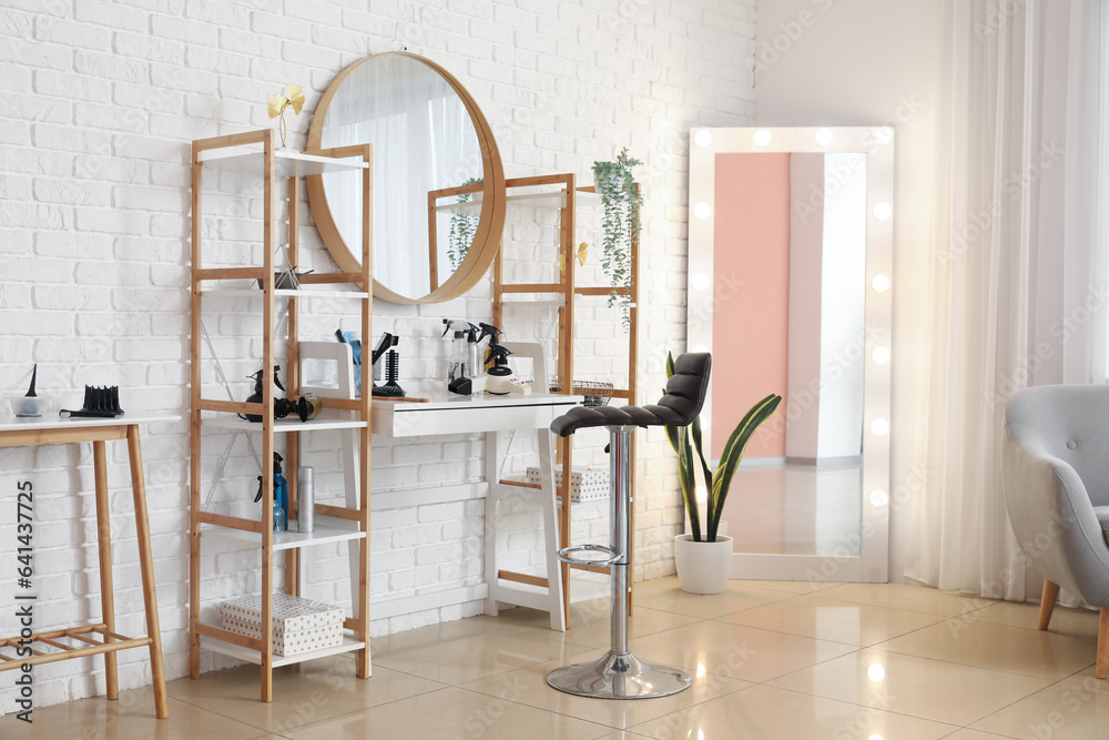 Interior of beauty salon with hairdressing table and mirrors