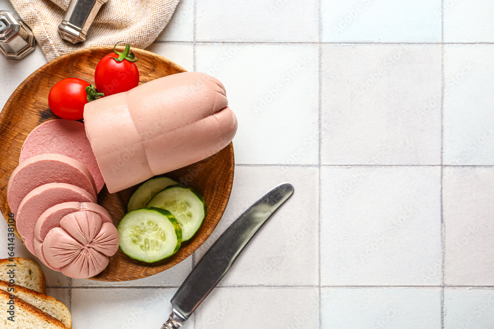 Plate with tasty boiled sausage on white tile background