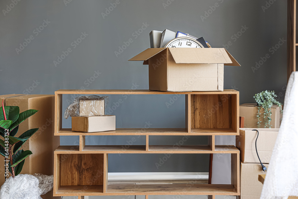 Shelving unit with cardboard boxes in modern office on moving day