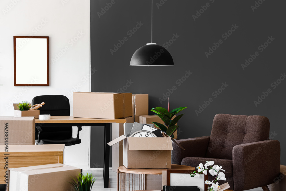 Interior of light office with cardboard boxes on moving day