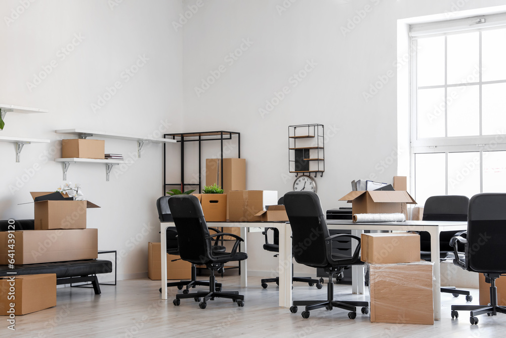 Interior of light office with cardboard boxes on moving day