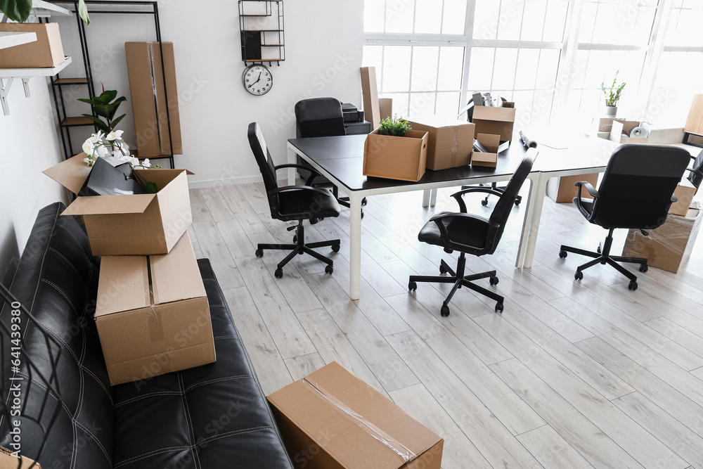 Interior of light office with cardboard boxes on moving day