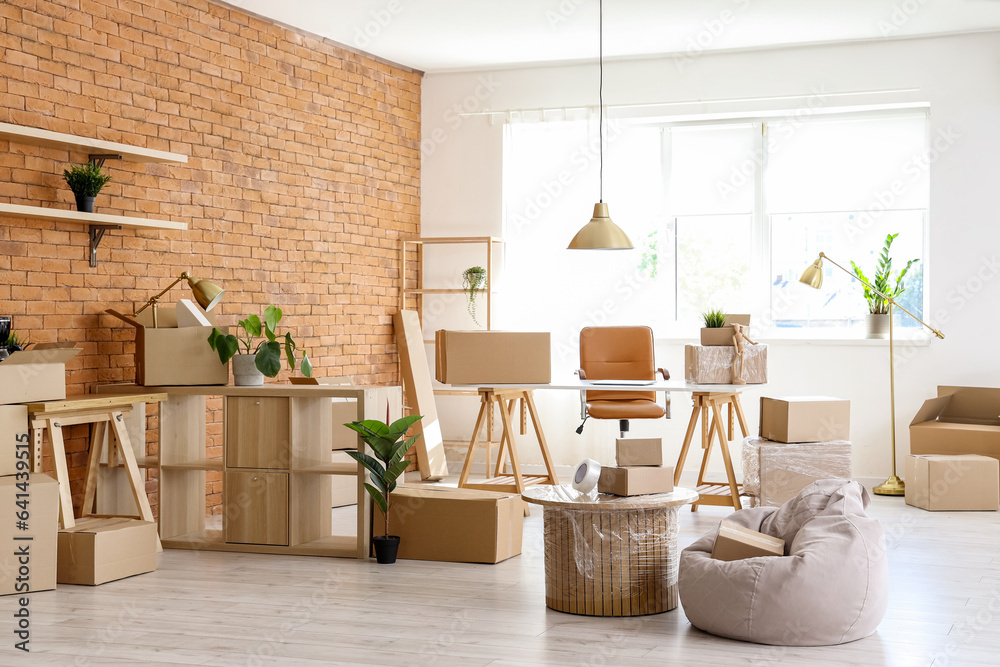 Interior of stylish office with cardboard boxes on moving day